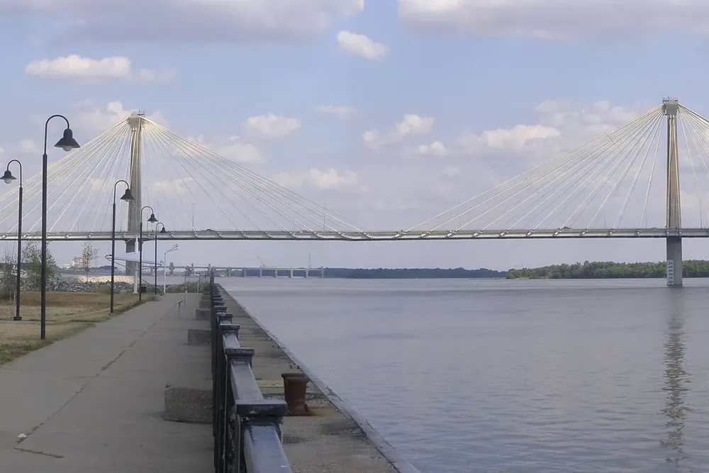 A cable-stayed bridge spanning the Mississippi River beside a riverside walkway in Alton, Illinois